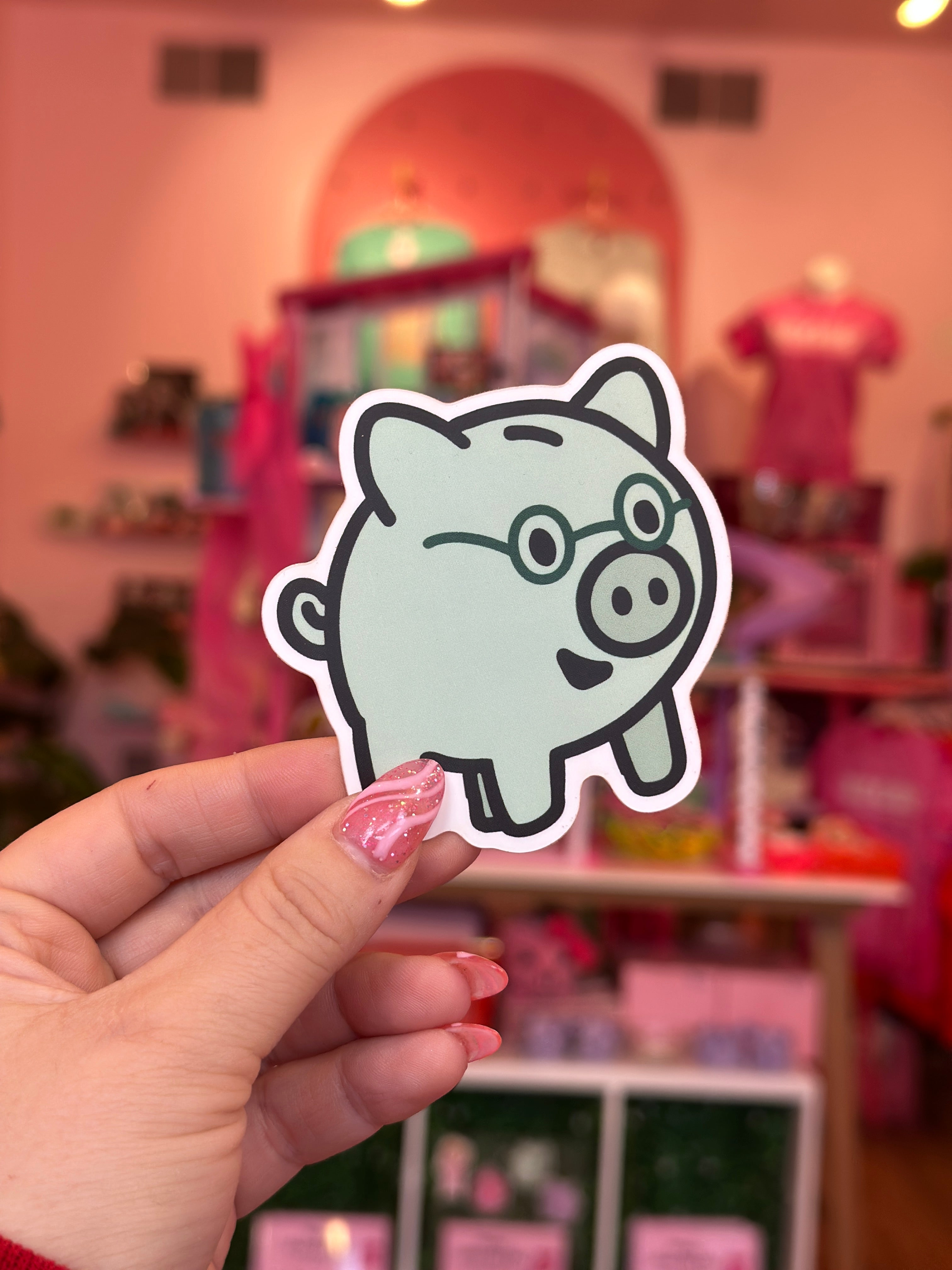 Hand holding a sticker of a cartoon character in a colorful room.