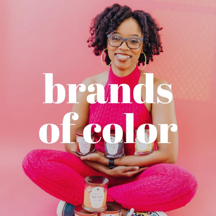 Black woman who is wearing a pink outfit and sitting cross-legged on the floor. She is holding candles from her candle company, Serene Nights. The words "Brands of Color" are typed in large white text in the center of the photo.