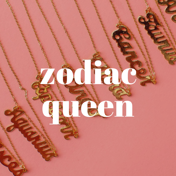 Gold necklaces with each zodiac name written in gold cursive lettering laying on a pink background. The words "Zodiac Queen" are typed in large white text in the center of the photo.