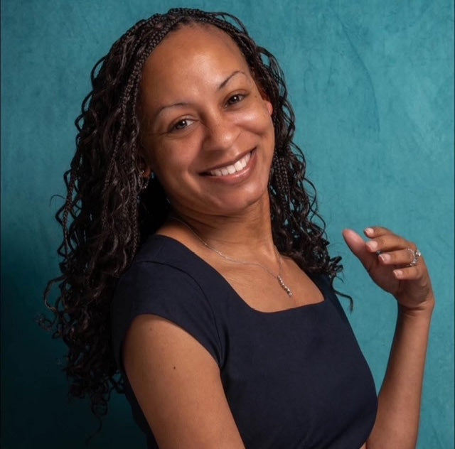 Woman with braided hair smiling against a teal background