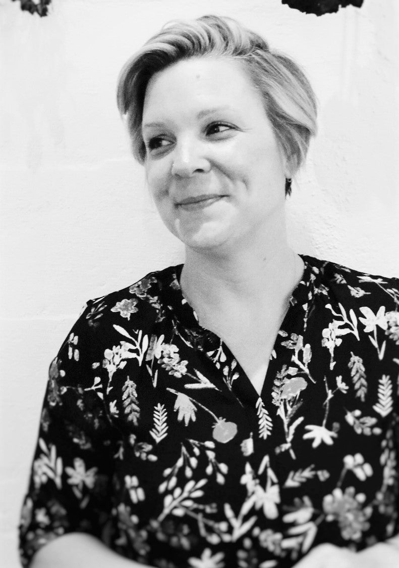 Black and white portrait of a person wearing a floral patterned shirt.