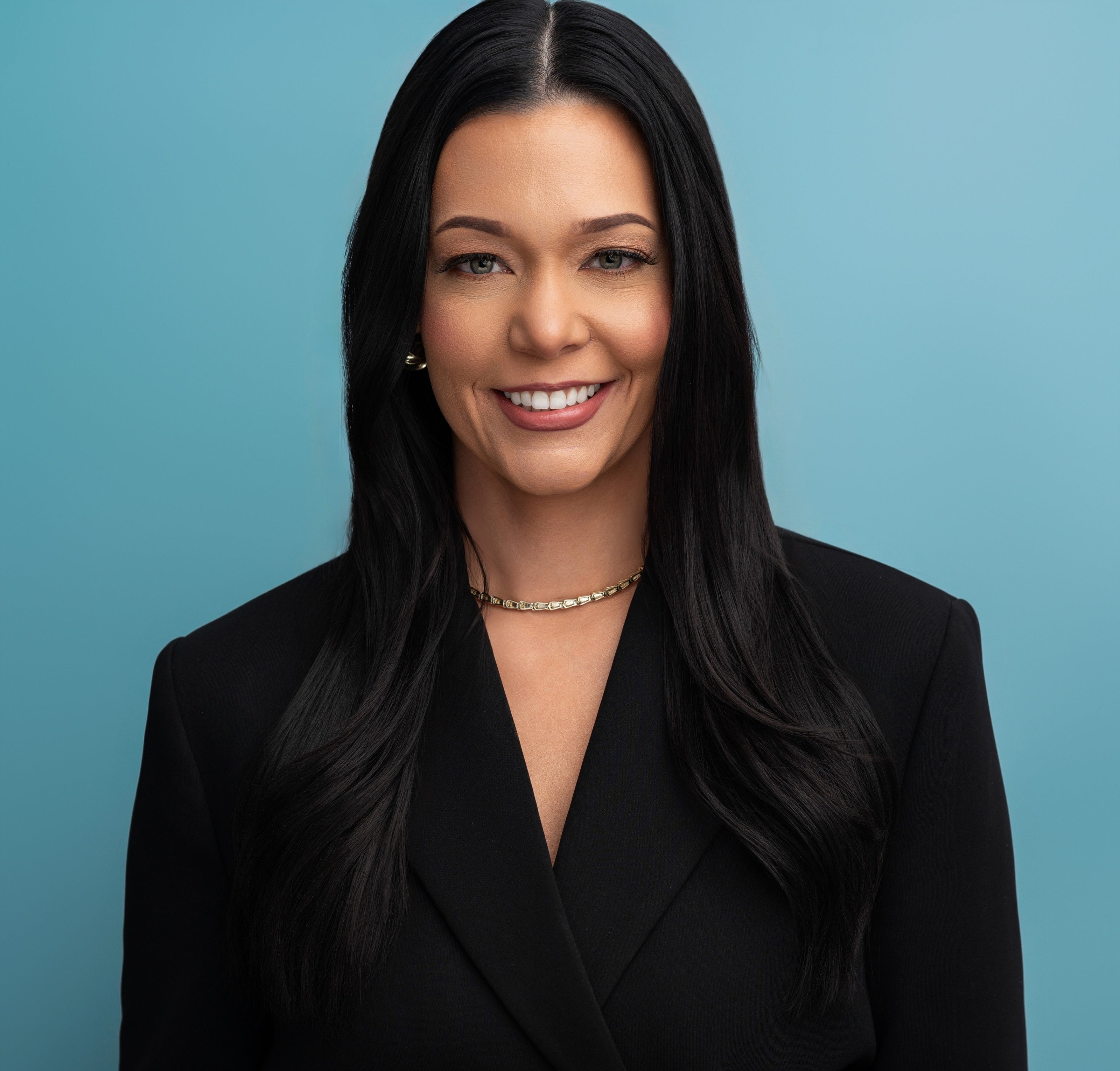 Woman wearing a black blazer against a blue background