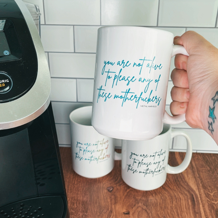 white mug with teal text reading ""you are not alive to please any of these motherfuckers"