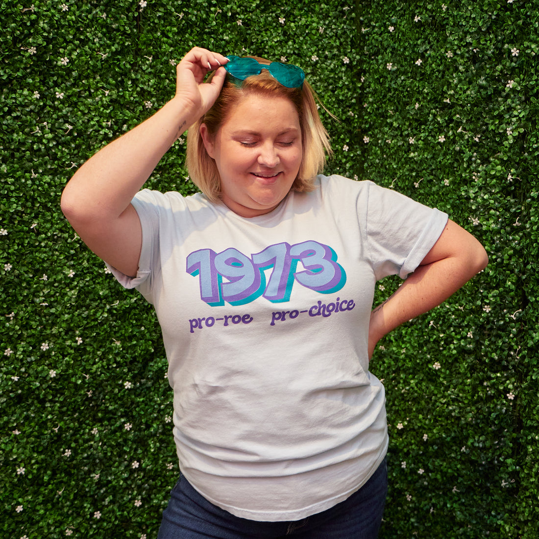 Woman wearing light blue t-shirt that says &quot;1973 Pro Roe, Pro Choice&quot; in light blue, purple, and teal retro-style fonts. Shirt was designed by Woman-Owned Wallet, a feminist gift shop in Louisville KY.