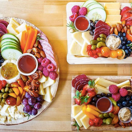 Assortment of charcuterie plates including a variety of cheese, meat, and fruit from Cultured Cheese Shop, one of the businesses featured on the Nulu Woman-Owned Walking Tour and Woman-Owned Directory hosted by WOW.