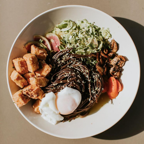 Vibrant grain and veggie bowl crafted by Naive Kitchen and Bar, one of the businesses featured on the Nulu Woman-Owned Walking Tour and Woman-Owned Directory hosted by Woman-Owned Wallet.