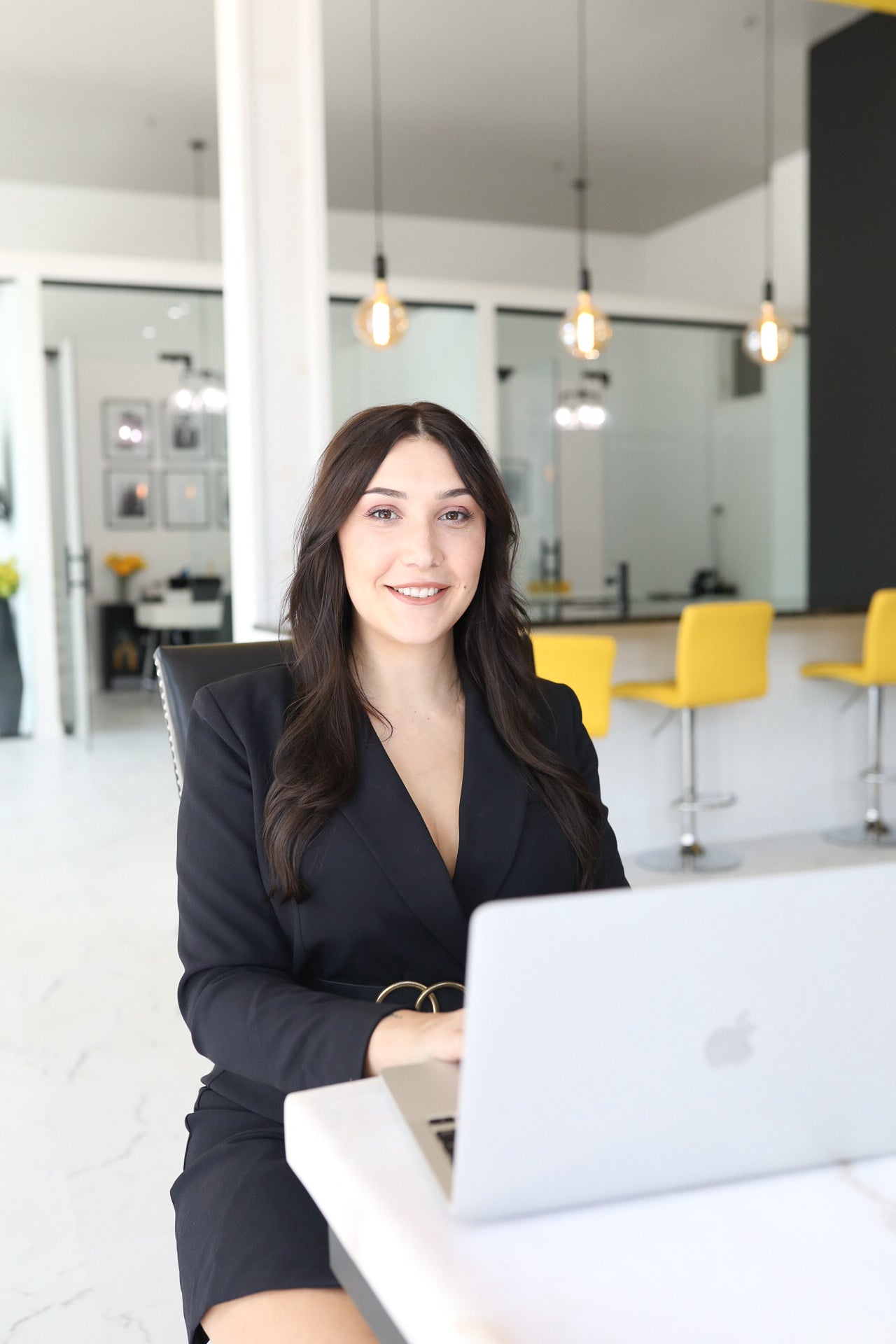 Woman sitting at a desk with a laptop in a modern office setting