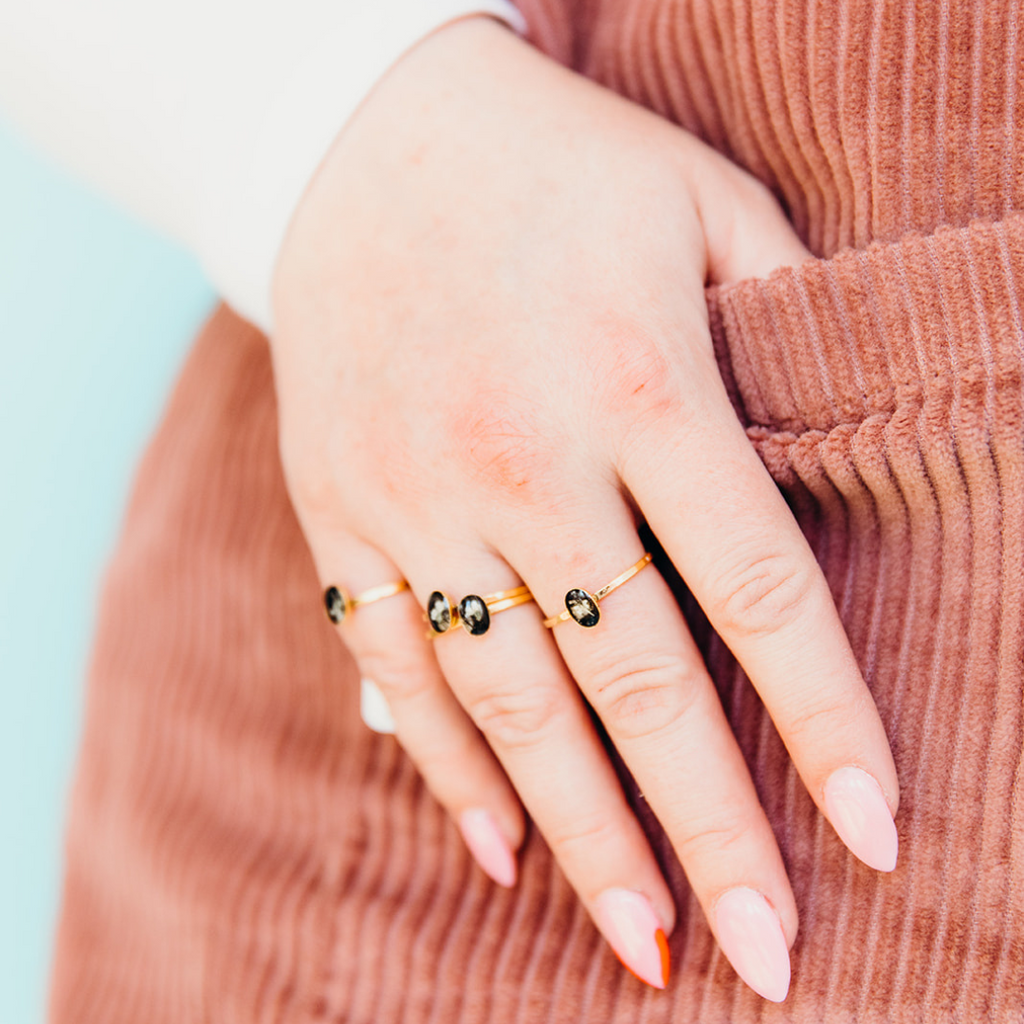 close up on hand wearing a cameo ring on each finger