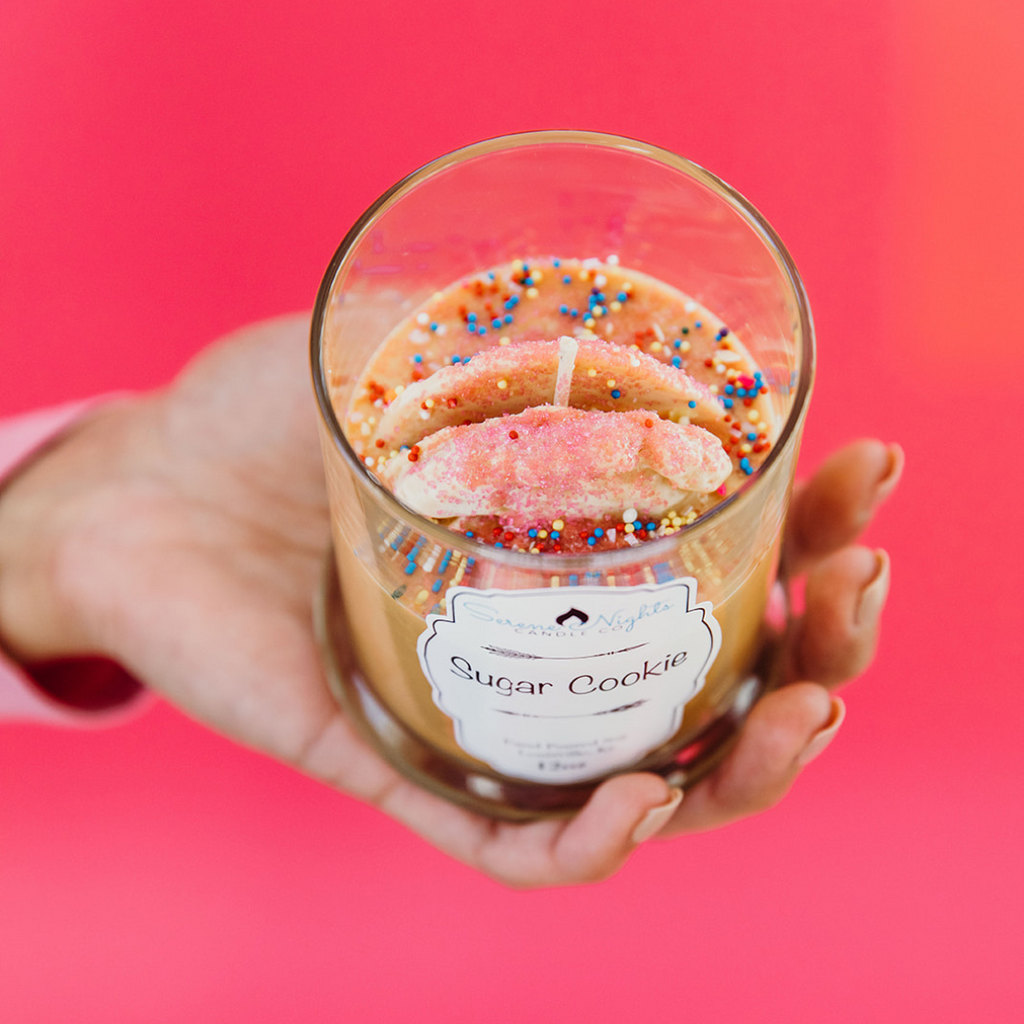 face down shot overlooking the top of the sugar cookie candle against pink background
