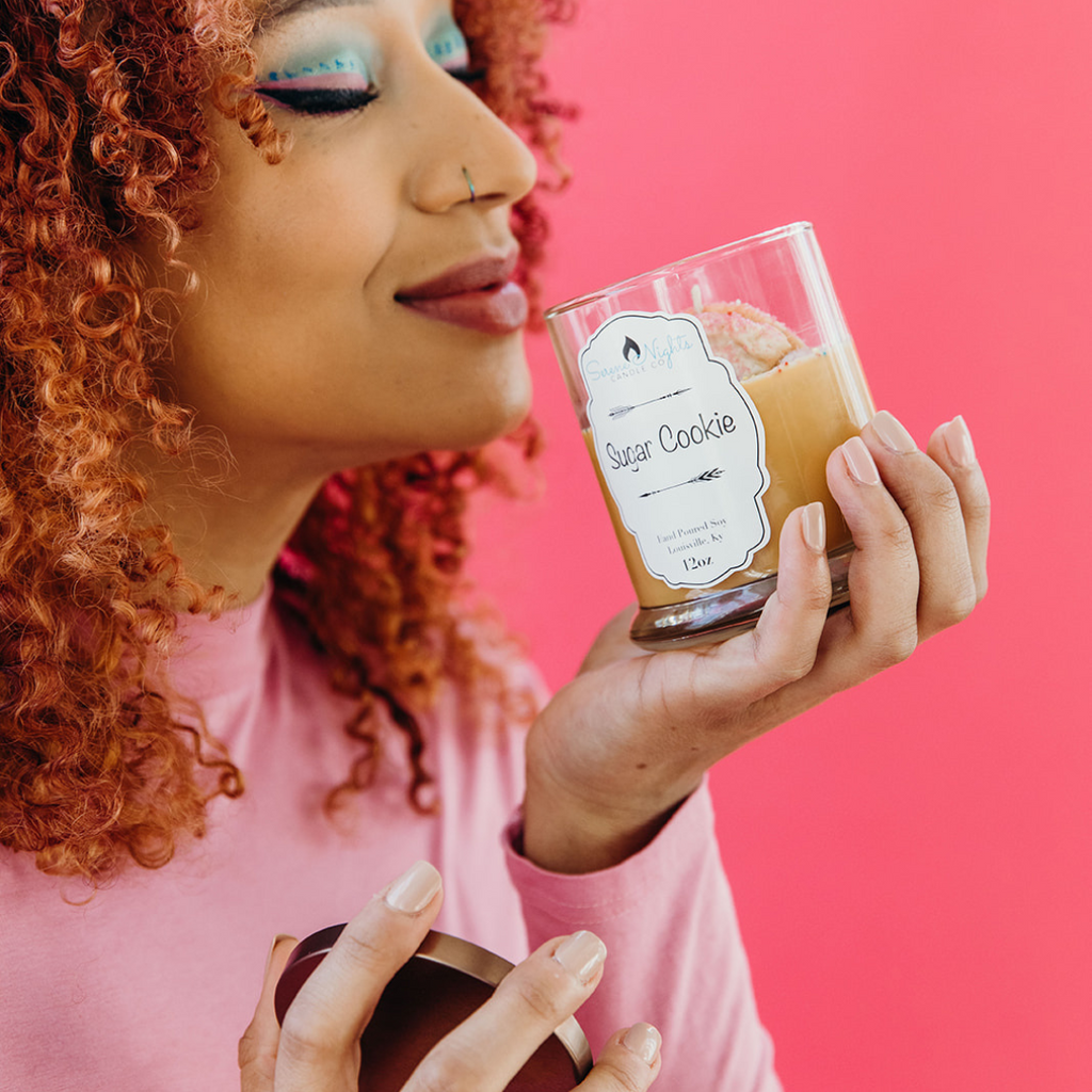 close up of woman smelling the sugar cookie candle
