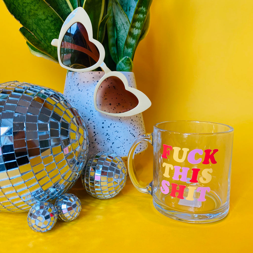 styled shot with background of plants and disco balls with Fuck This Shit mug in the forefront