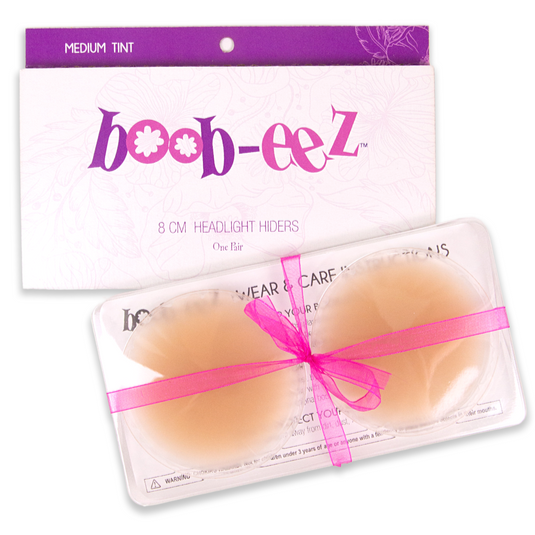 Package of nipple covers from the brand Boob-eez. Also shows the inner packaging including a plastic container that hold the silicone nipple covers in the color medium.