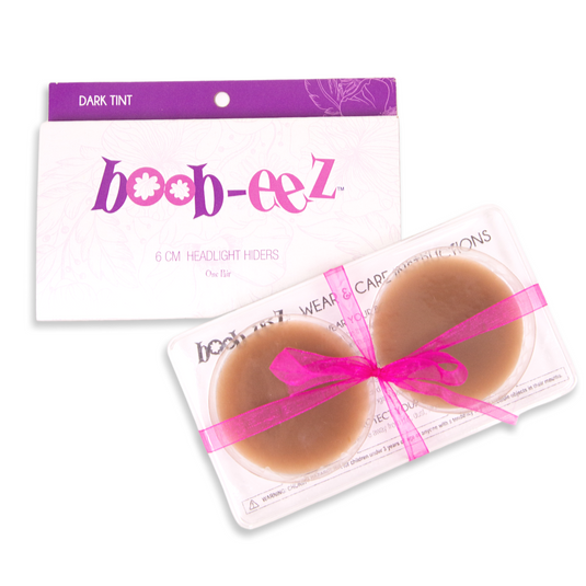 Package of nipple covers from the brand Boob-eez. Also shows the inner packaging including a plastic container that hold the silicone nipple covers in the color dark.